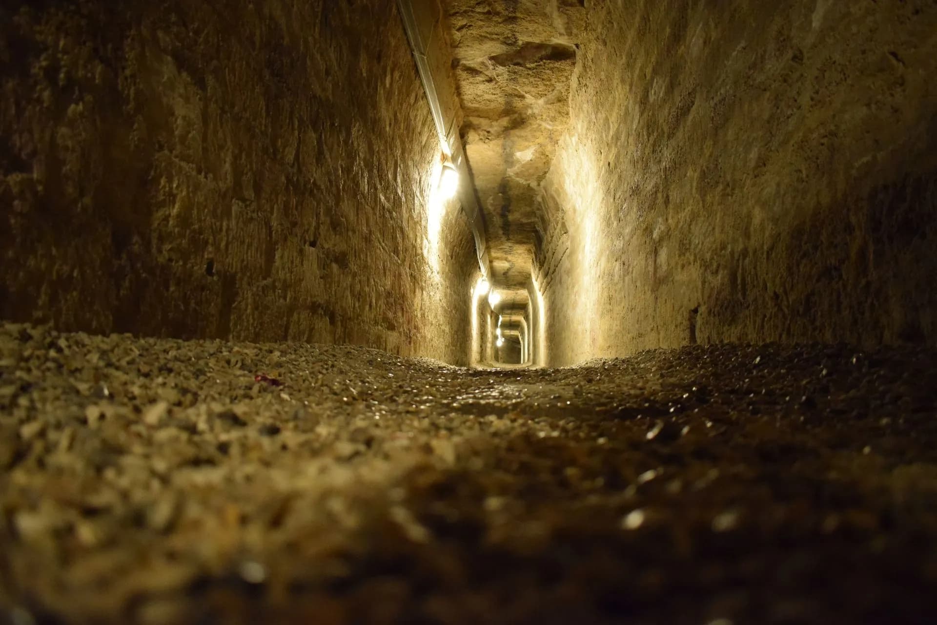Stacked human femurs and skulls arranged in a circular stone pit beneath the San Francisco monastery in Lima